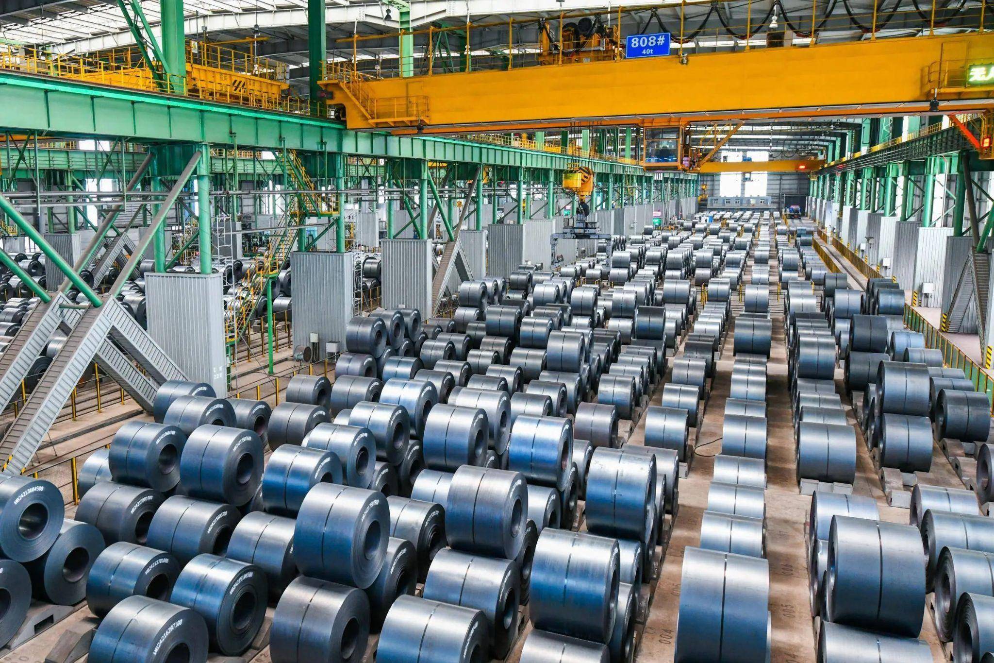 Large Chinese steel mill with rows of steel coils in production facility