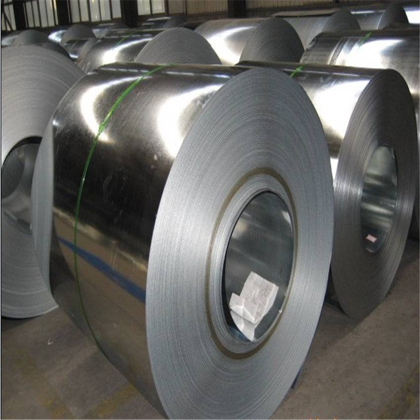  A large stack of shiny, silver galvanized steel coils in a bright, modern industrial warehouse.