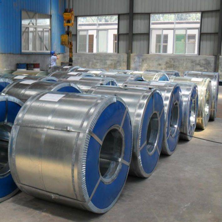 Multiple galvanized steel coils, neatly wrapped in protective waterproof paper and secured with steel straps, arranged on wooden pallets in a clean warehouse.