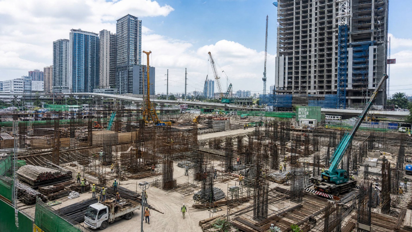 A large construction site in Manila with cranes and numerous structural steel beams and rebar in use for high-rise buildings as part of Build Better More.