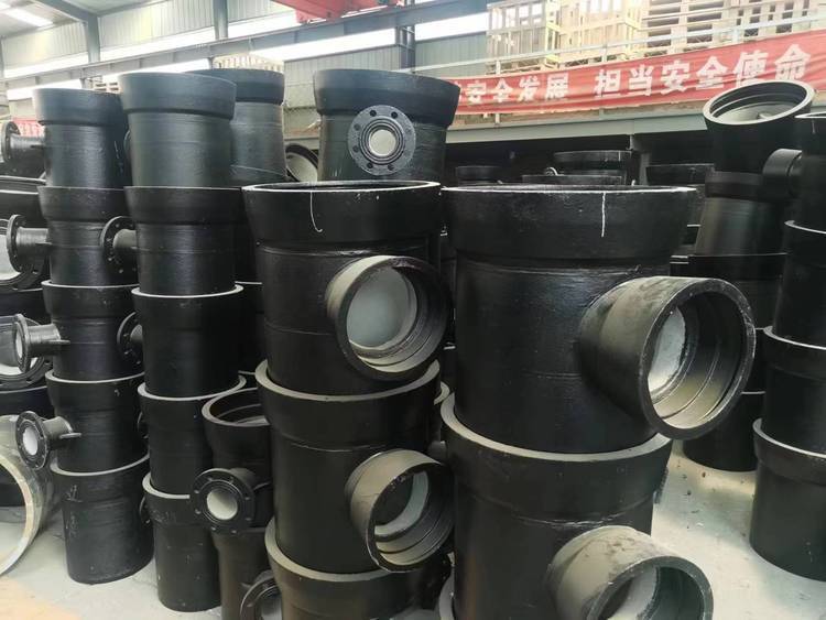 Stacks of black ductile iron tee pipe fittings manufactured according to SANS 657 South African standard
